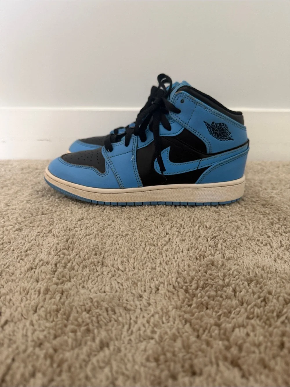 Nike Air Jordan 1 Mid shoes in the University Blue and Black colorway